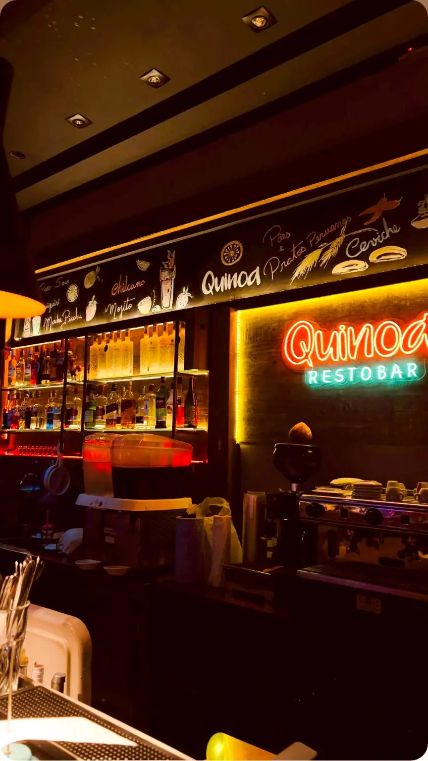 Bar do Quinoa Restobar com letreiro iluminado e decoração peruana
